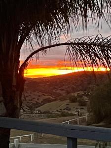 una puesta de sol vista desde un balcón con un árbol en Yurt Escape with Amazing Country Views, en Temecula