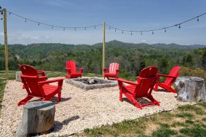 a group of red chairs sitting around a fire pit at Brackens View Retreat in Marshall