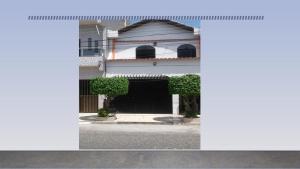 a white house with a black gate in front at Kit Net, Prox ao Centro in Belém