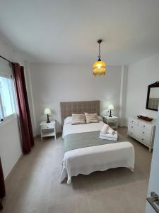 - une chambre avec un grand lit et 2 tables de chevet dans l'établissement Apartamento La Canela, à Nerja