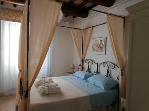 a bedroom with a canopy bed with towels on it at Residenza il Duomo in Nocera Umbra