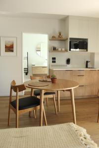 a living room with a table and a kitchen at māra in Mapua