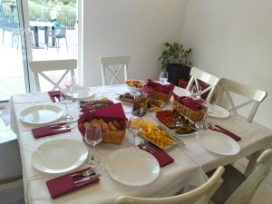 una mesa con platos y tazones de comida. en Camping Homes Grot en Gradac