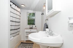 uma casa de banho branca com um lavatório e uma janela em Cabin Oasis em Marshall