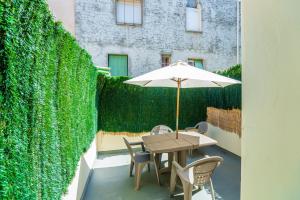 stół i krzesła z parasolem na patio w obiekcie Appartement Les Halles , Climatisation, Terrasse, Garage w mieście Narbona