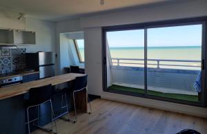 a kitchen with a large window with a view of the ocean at Lion Beach in Lion-sur-Mer