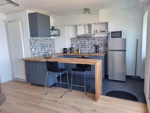 a kitchen with a wooden table and a refrigerator at Lion Beach in Lion-sur-Mer