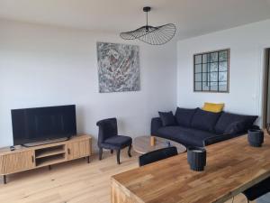 a living room with a couch and a tv at Lion Beach in Lion-sur-Mer