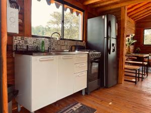 a kitchen with a refrigerator and a stove at BRUMA BLANCA CHALETS in Medellín