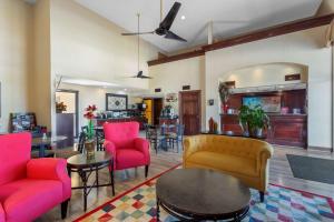 a living room with pink chairs and a table at Best Western Benton Inn in Benton