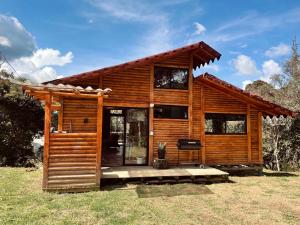 a wooden cabin with a large glass door at BRUMA BLANCA CHALETS in Medellín