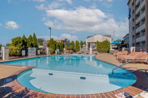 uma grande piscina num hotel com cadeiras em Best Western St Louis Kirkwood Route 66 em Saint Louis