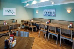 jadalnia z drewnianymi stołami i krzesłami w obiekcie Best Western New Smyrna Beach Hotel & Suites w mieście New Smyrna Beach