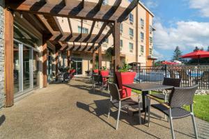 een patio met een tafel en stoelen en een gebouw bij Best Western Plus Revelstoke in Revelstoke