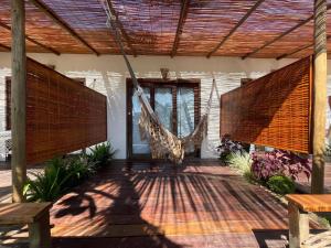 a porch with a hammock hanging from a house at Casa Nomade in Itarema