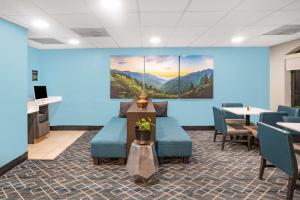 una sala de espera con paredes azules, mesas y sillas en La Quinta by Wyndham Sevierville / Kodak en Sevierville