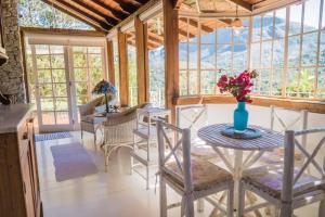 a dining room with a table with a vase of flowers on it at Quinta 59 - Sua Casa na Serra in Petrópolis