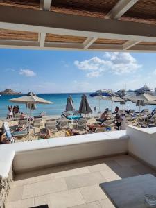 a view of a beach with chairs and umbrellas at Acrogiali Beachfront Hotel Mykonos in Platis Yialos Mykonos
