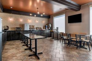 a kitchen with a table and chairs and a counter at Best Western Plus Edmundston in Edmundston