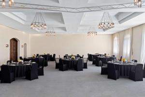 a room with black tables and chairs and chandeliers at Radisson Blu Resort El Quseir in Quseir +208 photos