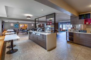 a large kitchen with a counter and a dining room at Best Western Plus West Edmonton in Edmonton