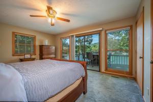 1 dormitorio con 1 cama, ventilador de techo y ventanas en Lake Al'Lure, en Lake Lure