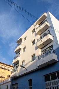 biały budynek z balkonami z boku w obiekcie PUESTA DE SOL RENTALS 2AJ w mieście Playa de San Juan