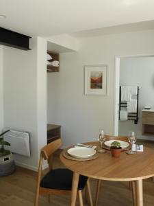 ein Esszimmer mit einem Holztisch und Stühlen in der Unterkunft māra in Mapua + 14 Fotos