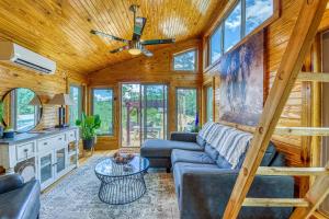a living room with a couch and a table at The Gemini-a dreamy, waterfront tiny cabin in Rogersville