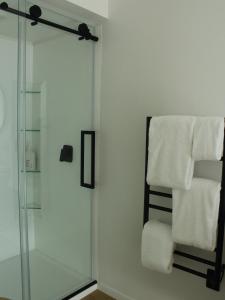 a bathroom with a glass shower and towels at māra in Mapua