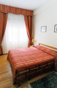 um quarto com uma cama grande e um cobertor vermelho em Eur Nir Residence em Roma