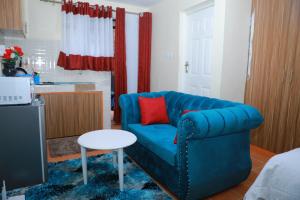 a living room with a blue couch and a table at Executive studio in Ruiru in Ruiru