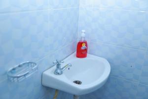 czerwona butelka mydła na białym zlewie w obiekcie Executive studio in Ruiru w mieście Ruiru