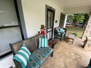 a porch with a bench with pillows on it at 11th St. Casa Blanca Bandera, TX. in Bandera