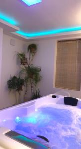 Paradis Du Nord في Wallers: حوض استحمام كبير مع أضواء زرقاء في الغرفة