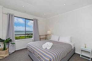 a bedroom with a bed with towels on it at Two Two Two in Port Fairy