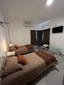 a bedroom with two beds and a television in it at Casa Vergara I in Villa Unión