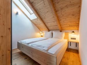 Łóżko w pokoju z drewnianym sufitem w obiekcie AlmApARTment Mauterndorf Pichl 9-5 w mieście Mauterndorf