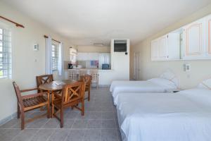 Zimmer mit 2 Betten, einem Tisch und Stühlen in der Unterkunft Ocean Bliss Apartments in Christchurch