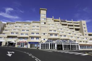 a large white building with a street in front of it at Aparthotel Los Dragos del Sur in Puerto de Santiago