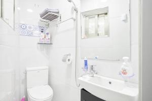 Un baño blanco con inodoro y lavabo. en Sweet Stay, en Seúl 97 fotos más
