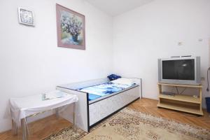a room with a bed and a tv and a table at Apartments with a parking space Orebic, Peljesac - 4546 in Orebić