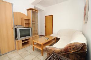 een kleine kamer met een bed en een televisie bij Family friendly seaside apartments Vlasici, Pag - 4319 in Vlašići