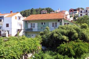 a house on the side of a hill with trees at Apartment Jelsa 4602c in Jelsa