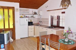 a kitchen with a wooden table and a dining room at Apartments by the sea Brna, Korcula - 5902 in Smokvica