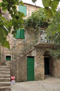 a stone building with a green door and stairs at Holiday house with WiFi Dol, Brac - 5674 in Postira