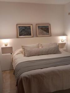 ein Schlafzimmer mit einem großen Bett mit zwei Bildern an der Wand in der Unterkunft Casa de Huéspedes La Aguada in Salta