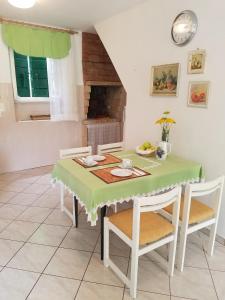 a dining room with a green table and chairs at Holiday house with WiFi Dol, Brac - 5674 in Postira