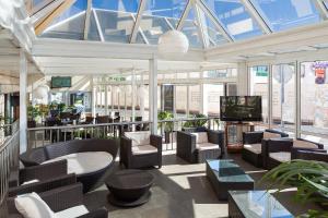 a large room with chairs and a television in a building at Aparthotel Los Dragos del Sur in Puerto de Santiago