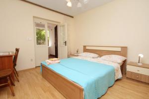 um quarto com uma cama grande e um cobertor azul em Apartments with a parking space Stari Grad, Hvar - 5724 em Stari Grad